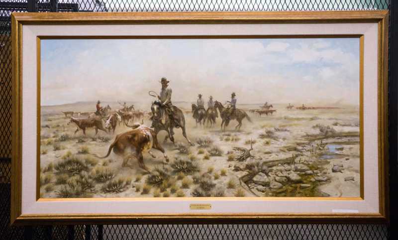 Depicts cowboys on horseback wra